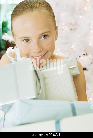 Frau mit Haufen von Geschenken vor Weihnachtsbaum Stockfoto