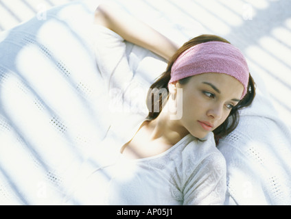 Junge Frau, die liegen im Schatten, nachdenklich Stockfoto