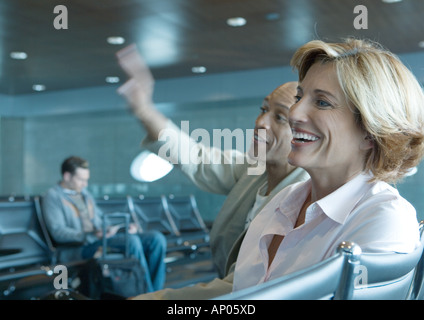 Mann und Frau im Flughafen-Lounge sitzen, lachen Stockfoto