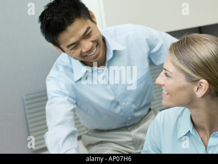 Männlichen und weiblichen Kollegen Lächeln einander an Stockfoto