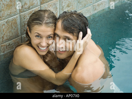Paar im Schwimmbad, Wange an Wange, lächelnd in die Kamera Stockfoto