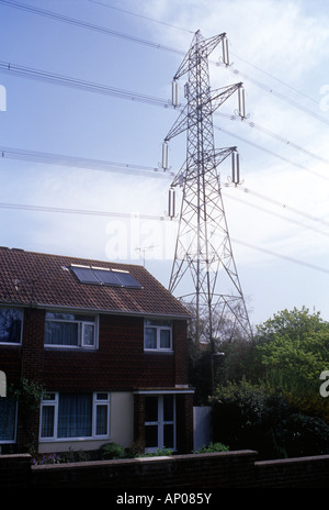 Fawley, Hampshire, UK. 1960er Jahre Haus direkt unter Netzspannung Linie kommt von Fawley Kraftwerk gebaut. Sonnenkollektoren auf dem Dach Stockfoto