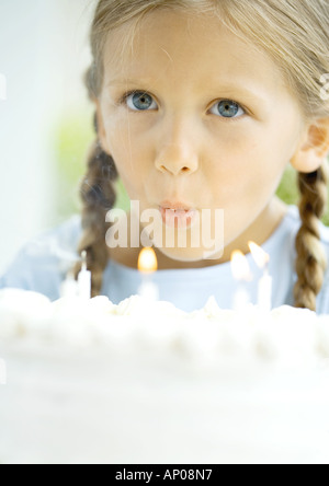 Kleines Mädchen bläst Kerzen auf Geburtstagskuchen Stockfoto