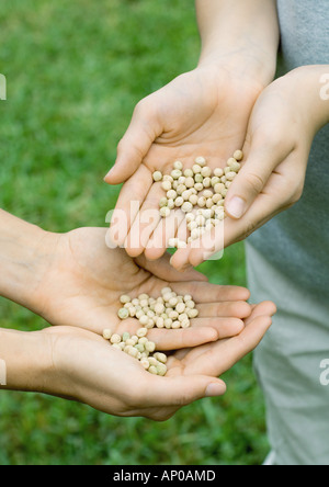 Eine Person, die zweite Person die Hände Samen überfluten Stockfoto