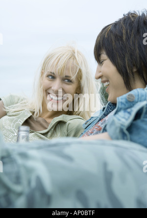 Zwei junge Frauen lehnen und lachen Stockfoto