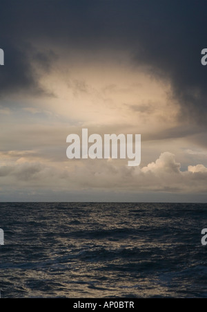 Stürmischer Himmel in der Abenddämmerung über das glitzernde Meer Stockfoto