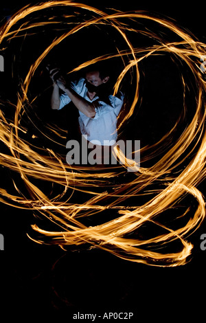 Mann Feuer tanzen mit Stöcken Feuer in der Nacht. Indien. Abstrakte Muster. Langzeitbelichtung Stockfoto