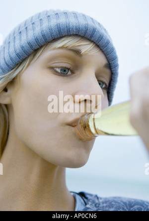 Junge Frau trinkt aus Flasche Bier, Nahaufnahme Stockfoto