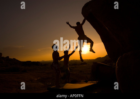 Männliche Felsen Kletterer Bouldern an die Dali-Felsbrocken in Hampi Indien bei Sonnenuntergang Stockfoto