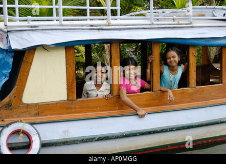 Drei Mädchen Lächeln in einem großen hölzernen Boot Stockfoto