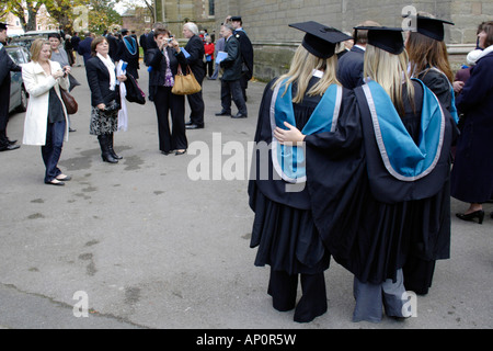 Absolventen aus Worcester Universität mit ihren Fotografien am Abschlusstag außerhalb Worcester Cathedral Stockfoto