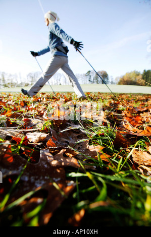 Junge Frau, die Nordic Walking durch Herbst Blätter, Voralpenland, Oberambach, Starnberger See, Bayern, Deutschland Stockfoto