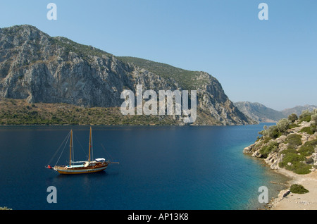 Eine Gulet verankert im mediterranen Meer unter antike Ruinen, Türkei. Stockfoto