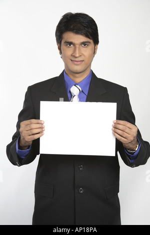 Blankopapier - Executive hält weißes Papier mit beiden Händen tragen schwarzen Anzug - Modell-Release Nr. 687M Stockfoto