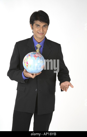ANG200080 Executive holding Globus seinen einerseits zeigt Indien und Lächeln auf den Lippen tragen schwarzen Anzug Model-Release Nr. 687 M Stockfoto