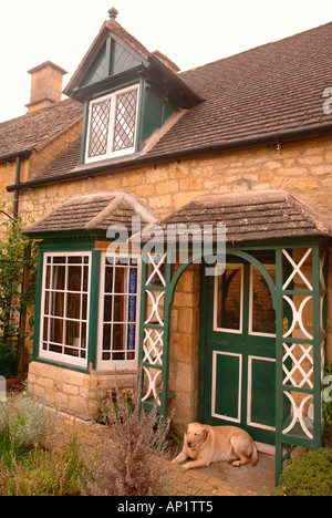EIN LABRADOR-JOB SCHLAFEN AUF DER VERANDA MIT EINEM GARTEN IM INNENHOF HINTEN AUF EINER HÜTTE GLOUCESTERSHIRE UK Stockfoto
