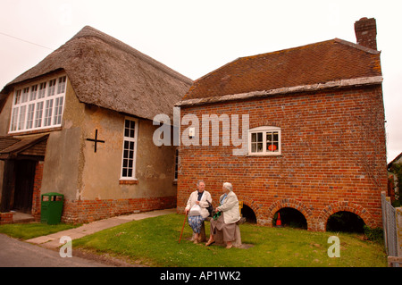 ZWEI ÄLTERE DAMEN IM CHAT OUTIDE, DORFLADEN UND POST AM BRIANTSPUDDLE IN DORSET UK Stockfoto