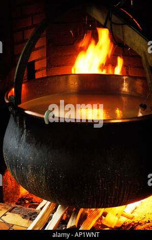 Große offene Holzfeuer in der Küche heizt der Kessel, die Milch enthalten, nachdem die Kultur hinzugefügt wurde. Stockfoto