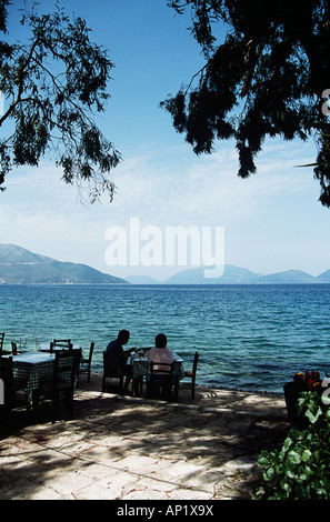 Zwei Menschen, die Restaurants und Bars direkt am Meer, Karavomilos, in der Nähe von Sami, Kefalonia, Griechenland Stockfoto