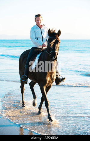 Frau auf einem Pferd am Ufer Meeres Stockfoto