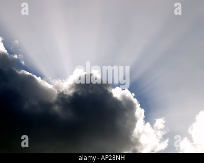Sonnenstrahlen nach oben von hinten eine schwarze Wolke Stockfoto