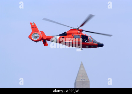 Ein Vereinigte Staaten Küstenwache HH - 65C Hubschrauber fliegen über George Washington Monument in Washington DC USA Amerika USA Stockfoto