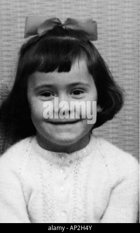 ALTE SCHWARZ-WEIß FAMILIENFOTO SNAP SHOT DES JUNGEN MÄDCHENS MIT IN IHR HAAR POSIERT FÜR EIN FOTO UM 1950 BEUGEN Stockfoto