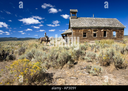 Cowboy mit Pferd am alten Schulhaus, Wildwest, Oregon, USA Stockfoto