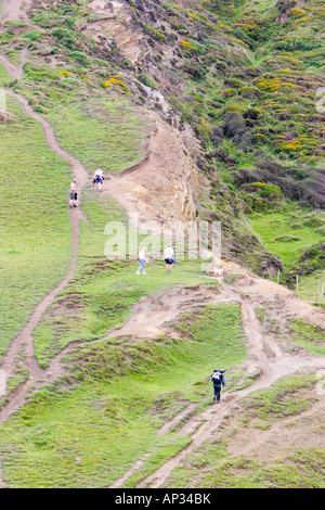 Wanderer auf einen sehr steilen Küstenweg führt weiter oben auf einer Klippe Stockfoto