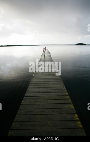 Zwei Menschen stehen auf einem hölzernen Steg an einem bewölkten Tag, Madkroken in der Nähe von Vaexjoe, Smaland, Schweden Stockfoto