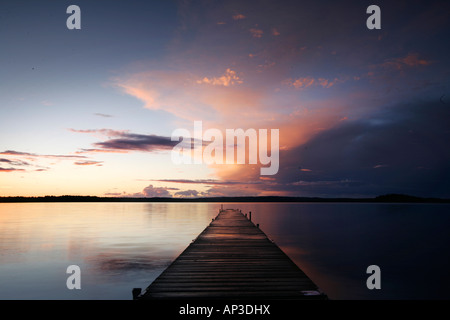 Steg an einem See bei Sonnenaufgang, Madkroken in der Nähe von Vaexjoe, Smaland, Schweden Stockfoto