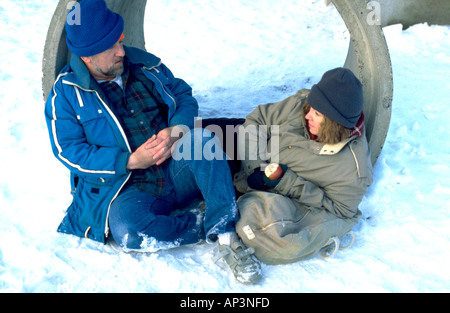Obdachlosen paar Alter 50 sprechen im Kanalrohr im Schnee. St Paul Minnesota MN USA Stockfoto