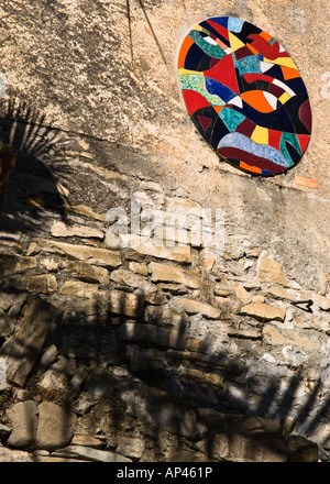 Eine kreisförmige Collage aus verschiedenen farbigen Kacheln an der Wand eines italienischen Dorfes Stockfoto