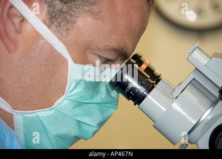 Chirurg Durchsicht Mikroskop während der Durchführung der Operation im Krankenhaus-OP-Saal Stockfoto