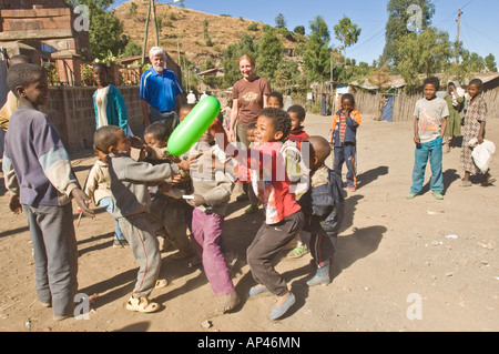 Kinder spielen "catch den Ballon" mit zwei Touristen, die gerne auf bei einem Besuch in Lalibela in Äthiopien. Stockfoto