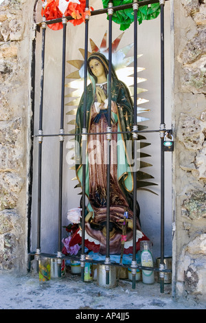 Liebe Frau von Guadalupe Skulptur in einem Votiv am Straßenrand Monument in der Nähe von Cusarare, eine Heimatgemeinde in der Sierra Tarahumara, Mexiko. Stockfoto