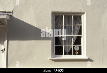 Detail von einem georgianischen Gebäude mit einem Fenster und einen Vorhang und eine Lampe im Inneren in Poole Dorset-England Stockfoto