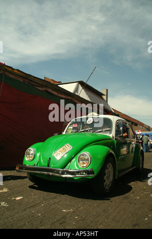 Ein grüner Volkwagen Käfer Taxi fährt entlang einer schmalen Seite Straße in Mexiko-Stadt Stockfoto