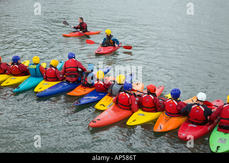 Bunte Kajaks auf dem Wasser zum Kanufahren Lektion mit Instruktor aufgereiht. UK Stockfoto