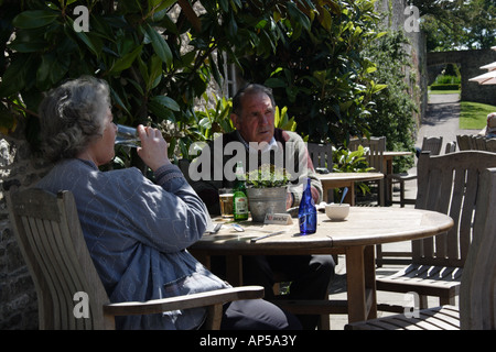 Paar im Café-Tisch mit Blick auf den Pool Garten Aberglasney House und Gärten, Llangathen, Camarthenshire, West Wales, Stockfoto