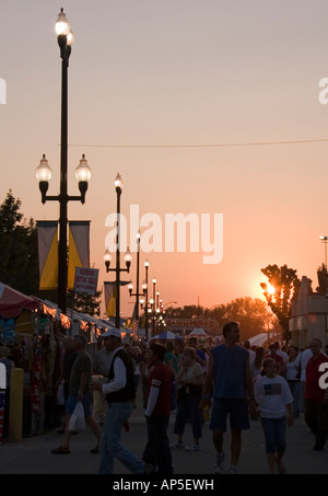 Schutzherren & Besucher von der Utah State Fair zu Fuß der Midway Einbruch der Dunkelheit nähert. Die Sonne ist fast untergegangen & alles ist im Schatten. Stockfoto