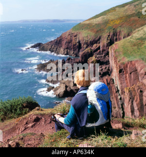 Frau zu Fuß auf dem Meer Küstenpfad von Süd-Wales in der Nähe von Manorbier, Pembrokeshire, Wales UK Stockfoto