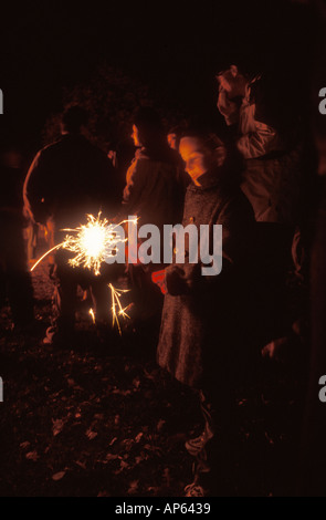 Kind hält eine Wunderkerze am Lagerfeuer-Abend Stockfoto