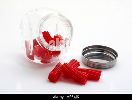 Stücke von rote Lakritze auf Glas Glas isoliert auf weißem Hintergrund Stockfoto