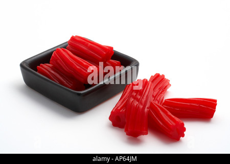 Stücke von rote Lakritze auf schwarz Schüssel isoliert auf weißem Hintergrund Stockfoto