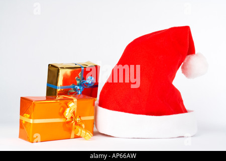 Weihnachtsmütze und zwei Geschenke auf weißem Hintergrund Stockfoto