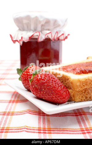 Zwei Erdbeeren und Popups in einer Schale vor Jam jar flachen DOF Stockfoto