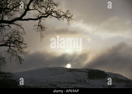 Die Sonne wird verdeckt durch Cockelroy Hügel in der Nähe von Linlithgow Schottland Wintersturm überfahren. Stockfoto