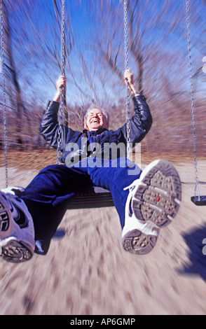 Älterer Mann genießen eine Schaukel Stockfoto