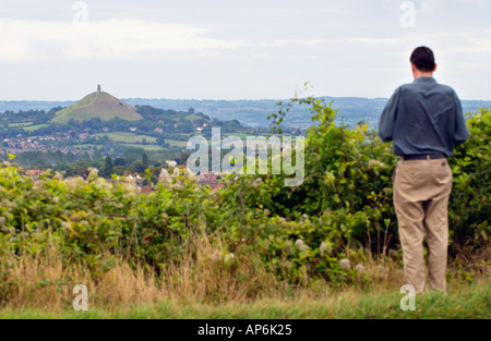 Glastonbury Tor steigt aus der Landschaft betrachtet über Wohnsiedlungen Glastonbury Somerset England UK Stockfoto